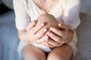 Mother resting gently with her newborn during the fourth trimester