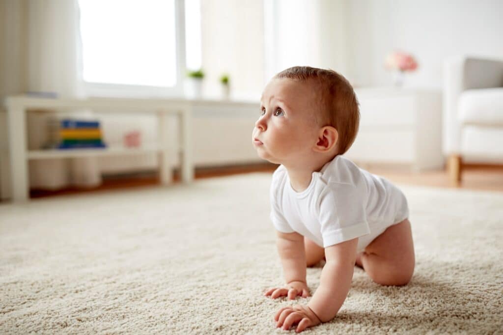 Baby crawling on rug in living room