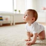 Baby crawling on rug in living room