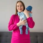 Mother holding her newborn baby at home during postpartum recovery